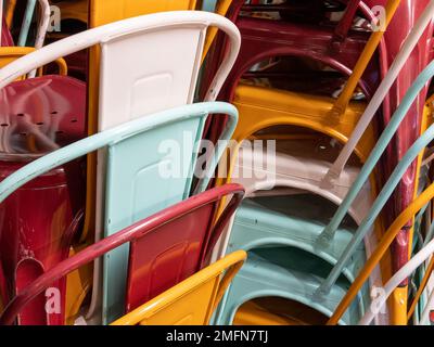 Stahlstapel aus mehrfarbigen Industriestühlen Metall Stockfoto