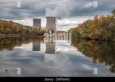Kühltürme des Kernkraftwerks Cruas mit dramatischen Rauchwolken im See Stockfoto