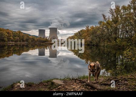 Kühltürme des Kernkraftwerks Cruas mit dramatischen Rauchwolken im See Stockfoto