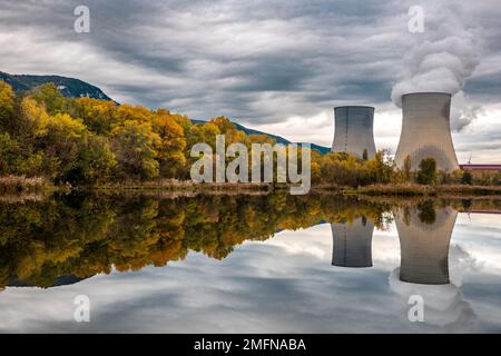 Kühltürme des Kernkraftwerks Cruas mit dramatischen Rauchwolken im See Stockfoto