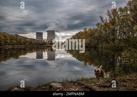 Kühltürme des Kernkraftwerks Cruas mit dramatischen Rauchwolken im See Stockfoto