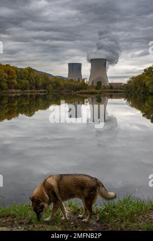 Kühltürme des Kernkraftwerks Cruas mit dramatischen Rauchwolken im See Stockfoto
