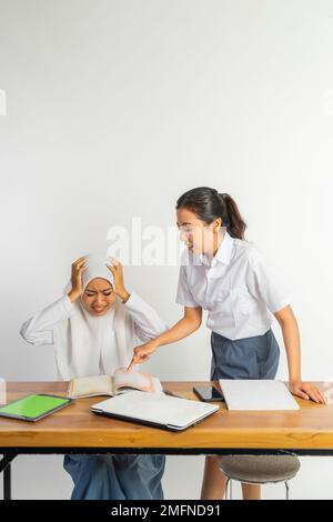 Zwei gestresste Highschool-Mädchen an der Rezeption, während sie wütend waren Stockfoto