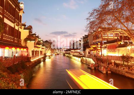 NANJING, CHINA - 24. JANUAR 2023 - Touristen fahren mit dem bemalten Boot und genießen die Landschaft des Konfuzius-Tempels entlang des Qinhuai-Flusses in Nanjing, EA Stockfoto
