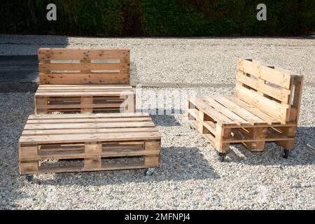 Recycelte Felgenbank aus alter Holzlagerpalette für heimwerker im Garten Stockfoto