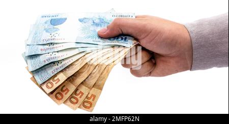 Hand auf isoliertem weißen Hintergrund, der brasilien Geld bietet, hundertfünfzig Reais-Banknoten, brasilianische Wirtschaft. Stockfoto