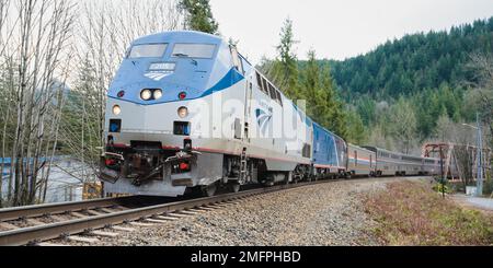 Index, WA, USA - 16. Januar 2023; Amtrak Empire Builder Sleeper Train fährt im Winter um eine Kurve Stockfoto