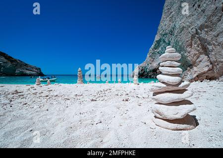 Blick auf cairns, Stapel von ausgewogenen weißen runden Steinen, am wunderschönen weißen Strand auf Zakynthos, Griechenland, umgeben von tropischem türkisfarbenem Wasser Stockfoto