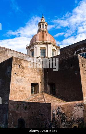 Die Kuppel der Kirche San Nicolò l'Arena, Chiesa di San Nicolò l'Arena, erhebt sich über den dicken Mauern des Gebäudes in der Altstadt von Catania. Stockfoto