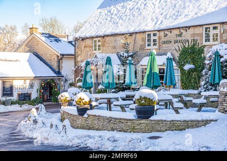 Frühwinterschnee im Green Dragon Inn Pub & Shop im Cotswold-Dorf Cockleford in der Nähe von Cowley, Gloucestershire, England Stockfoto