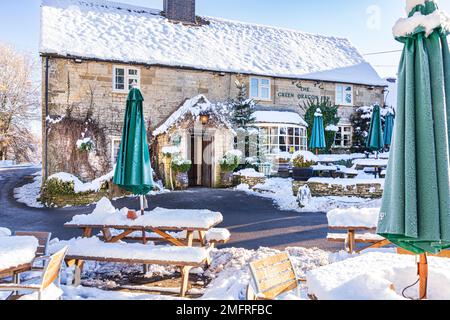 Frühwinterschnee im Green Dragon Inn Pub im Cotswold-Dorf Cockleford in der Nähe von Cowley, Gloucestershire, England Stockfoto