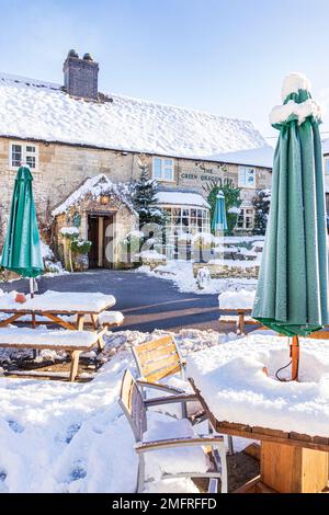 Frühwinterschnee im Green Dragon Inn Pub im Cotswold-Dorf Cockleford in der Nähe von Cowley, Gloucestershire, England Stockfoto