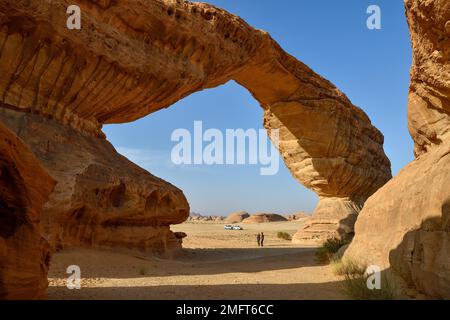 Touristen am Arch, auch bekannt als Rainbow Rock, in der Nähe von Alula, Medina Province, Saudi-Arabien, Arabische Halbinsel Stockfoto