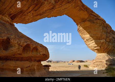 Touristen am Arch, auch bekannt als Rainbow Rock, in der Nähe von Alula, Medina Province, Saudi-Arabien, Arabische Halbinsel Stockfoto