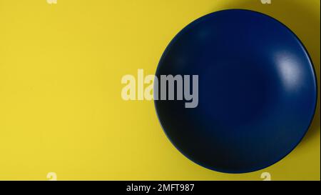 Leeres blaues Schild auf gelbem Hintergrund. Flach liegend mit Kopierbereich Stockfoto