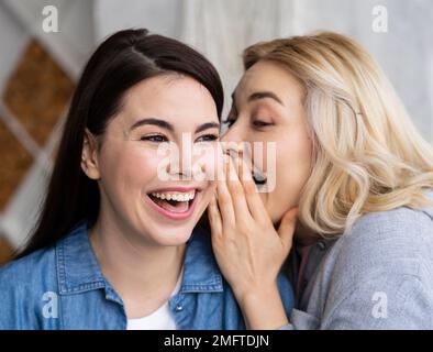 Frauen, die Geheimnisse erzählen und lachen Stockfoto