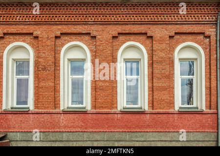 Teil der Mauer mit Fenstern der Kirche der Fürsprache des Heiligen Theotokos. Foto gemacht in Kopeysk, Region Tscheljabinsk, Russland. Stockfoto