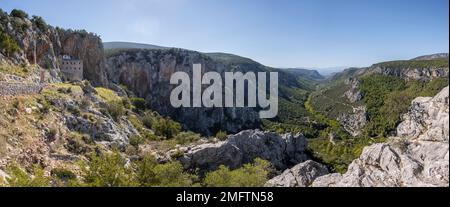 Das antike byzantinische Kloster Ei an einer Felswand, Iera Moni Agiou Dimitriou Augou, Blick in ein Tal mit Felswänden in den Bergen Stockfoto