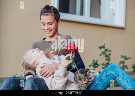 Ein Teenager, der sich verliebt hat. Die ersten Kinder lieben es, dass ein Teenager einem Mädchen Blumen schenkt. Stockfoto