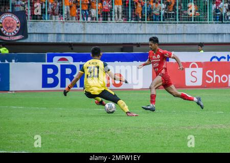 Indonesien. 25. Januar 2023. Aji Kusuma (Rot) (Persija Jakarta) hat den Torwart von PSM Makassar bei der Fortsetzung des Fußballspiels der Indonesischen Liga 1 in Woche 20 im Patriot Candrabhaga Stadium, West Java, bestanden. Persija Jakarta konnte dank der Tore von Abdulla Yusuf Helal (2) und Aji Kusuma (2) mit 4-2 Punkten gewinnen. (Foto: Ahmad Soleh/Sipa USA) Guthaben: SIPA USA/Alamy Live News Stockfoto