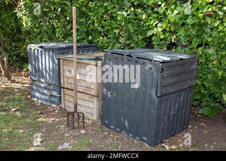 Gartengabel zum Verdrehen von schwarz kompostiertem Boden in Holz- und Kunststoffkompost Stockfoto
