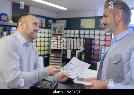 Kunde und Konstrukteur diskutieren Projekt in der Agentur Stockfoto