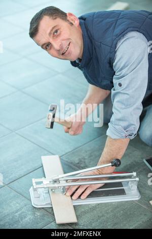 Glückliches professionelles Schneiden von Keramikfliesen Stockfoto