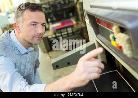 Männliche Weingut Arbeiter mit der Abfüllung von Maschinen im Werk Stockfoto