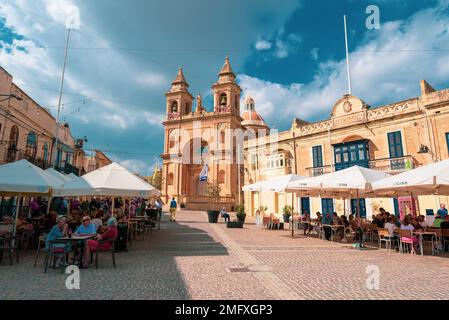 Marsaxlokk, Malta, Europa - 22. Oktober 2022: Touristen genießen den Urlaub auf den Terrassen am zentralen Platz der Stadt Marsaxlokk und die Tradition Stockfoto