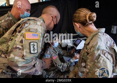 USA Armeebrig. Gen. Peder Swanson, Stellvertretender Befehlshaber des 3. Medizinischen Kommandos (Einsatzunterstützung), Oberst Katie Suarez, Befehlshaber der 338. Brigade, Und Kommandoleiter Major Nathaniel Chapman, KommandoSergeant Major der 338. Brigade, beobachten SPC. Joanna Rodriguez, eine Optikerin mit NORA, Brillen zur Qualitätskontrolle während des Appalachian Care Innovative Readiness Training (IRT) 2022 in Wise, Virginia, 20. August 2022. IRT ist eine militärische Ausbildungsmöglichkeit des Verteidigungsministeriums (DoD), die exklusiv für die Vereinigten Staaten und ihre Territorien angeboten wird und gemeinsame Schulungsmöglichkeiten bietet, um den Einsatz zu erhöhen Stockfoto