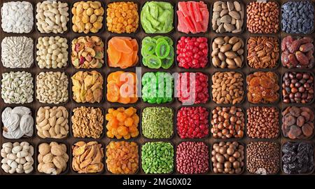Gemischte Nüsse und Samen, verschiedene getrocknete Früchte zum Snack. Farbenfroher kulinarischer Hintergrund. Stockfoto