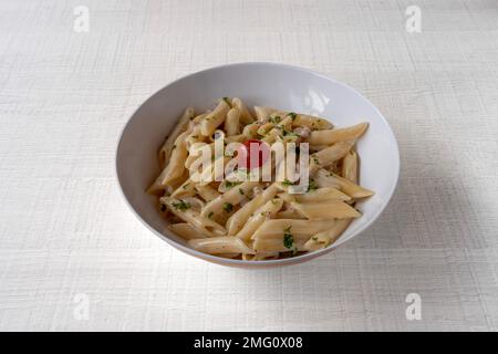 Italienisches Dishe kulinarisches Still Life. carbonara Pasta mit Penne Pasta, Speck und Tomaten Stockfoto