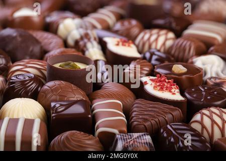 Milch und dunkle Schokoladenbonbons im Hintergrund, süßes Gourmet-Dessert. Stockfoto