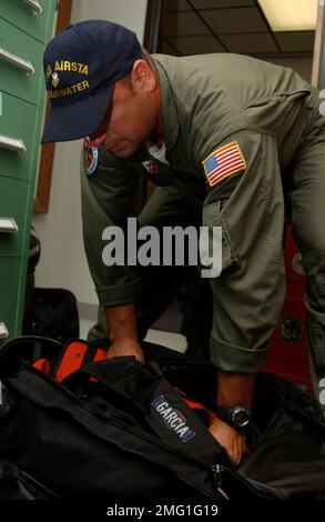 Strukturen der Küstenwache - Luftwaffenstützpunkte - Operationen - 26-HK-96-110. AIRSTA OPS--Küstenwachmann packt Ausrüstung im Gebäude. Hurrikan Katrina Stockfoto