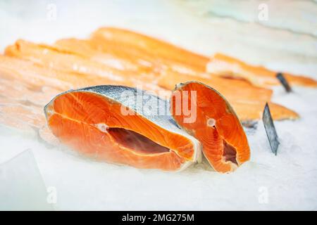 Frische Lachssteaks auf Eis zum Verkauf in der Nähe des Supermarkts. Konzept der gesunden Ernährung Stockfoto