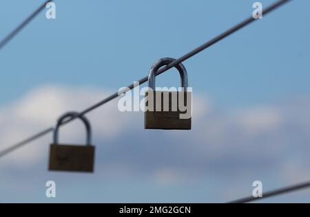 Nahaufnahme von Lovelocks, die an einem Metallzaun hängen Stockfoto
