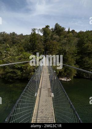 Leere Seilbahn-Fußbrücke, die sich über den Süßwasserstrom des Flusses im Abel Tasman National Park South Island Neuseeland erstreckt Stockfoto