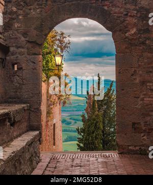 Stadtbild. Blick auf eine enge mittelalterliche Straße im historischen Zentrum am sonnigen Frühlingstag in Pienza, Italien Stockfoto