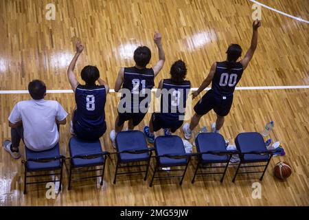 Mitglieder des Basketballteams Rising Warriors jubeln während eines US-japanischen Basketballturniers, das von der Marine Corps Air Station Iwakuni Marine Corps Community Services im Atago Sports Complex in Iwakuni, Japan, am 21. August 2022 veranstaltet wurde. Das Turnier war offen für aktive Dienstmitglieder und Installationsangehörige und sollte eine Kameradschaft innerhalb der örtlichen Gemeinde aufbauen. Basketball, Intramurale Sportarten, Japan, MCAS Iwakuni, Turnier, USA-Japan, Stockfoto