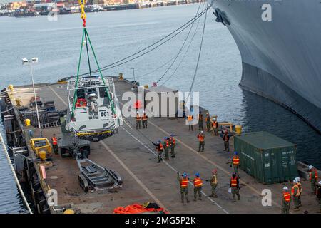 Long Beach, Kalifornien, USA. 12. Januar 2023. Matrosen, die dem Maritime Expeditionary Security Squadron (MSRON) 11 und dem Navy Cargo Handling Battalion (NCHB) 14 zugeteilt sind, führen eine Hebekonfiguration für ein 34-Fuß Sea Arc Patrouillenboot während eines LO-LO-Trainings an Bord des SS Cape Inscription (T-AKR-5076) im Hafen von Long Beach, Kalifornien, Januar durch. 12. Die NCHB liefert Expeditionslogistikkapazitäten mit Matrosen und Ausrüstung der Marinereservekräfte für die Kombattantbefehle zur Unterstützung der nationalen Militärstrategie, die für Friedenssicherung, Krisenreaktion und Humanitar von entscheidender Bedeutung ist Stockfoto