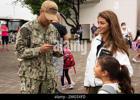 YOKOSUKA, Japan (22. August 2022) — Aviation Boatswain’s Mate (Fuel) 3. Class Gabriel Vega, zugewiesen an Naval Supply Systems Command, Fleet Logistics Center Yokosuka, und seine Familienmitglieder feiern den ersten Schultag in der Sullivans Elementary School Onboard Commander, Fleet Activities Yokosuka (CFAY). Am Montag, den 22. August, war der erste Tag des Schuljahres 2022-2023 für fast alle DoDEA-Schulen im Pazifik. Seit mehr als 75 Jahren stellt CFAY Basiseinrichtungen und -Dienste zur Unterstützung der US-Flotte 7. bereit, wartet und betreibt diese Stockfoto