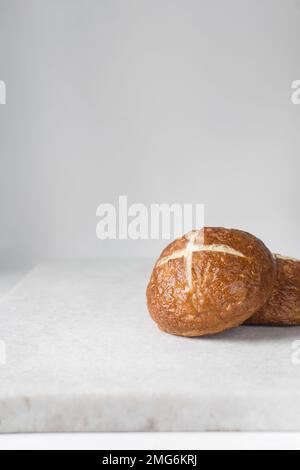 Blick von oben auf Bretzelbrötchen auf einem Marmortablett, deutsche Laugenbroetchen auf einem Marmortablett Stockfoto