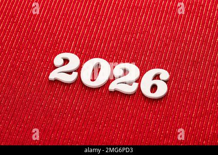 Frohes neues Jahr 2026 in weißen Buchstaben auf rotem Hintergrund Stockfoto