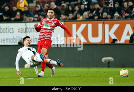 Augsburg, Deutschland. 25. Januar 2023. Dion Beljo (R) aus Augsburg wehrt sich mit Julian Weigl aus Moenchengladbach während des deutschen Bundesliga-Fußballspiels in der ersten Spielklasse zwischen dem FC Augsburg und der Borussia Moenchengladbach in Augsburg am 25. Januar 2023. Kredit: Philippe Ruiz/Xinhua/Alamy Live News Stockfoto