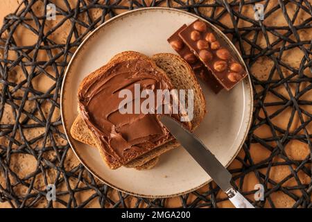 Teller mit leckerem Toast mit Haselnussbutter und Schokolade auf dem Tisch Stockfoto