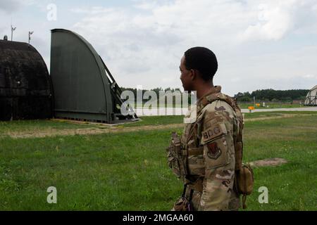 USA Air Force Airman 1. Class Austin Waters, 824. Base Defense Squadron Fire Team Mitglied, bewacht einen F-22 Raptor, der der 90. Expeditionary Fighter Squadron, 22. August 2022, auf dem Luftwaffenstützpunkt Łask, Polen, zugeteilt wurde. Der 824. BDS ist Teil der 820. Base Defense Group mit Sitz in Moody Air Base, Georgia. Der 824. BDS-Forward wurde vom Luftwaffenstützpunkt Ramstein, Deutschland, eingesetzt, um den 90. EFS bei der Durchführung der NATO-Luftabschirmung zu unterstützen. Stockfoto