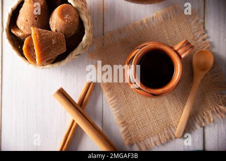 Cafe de Olla. Traditioneller mexikanischer Kaffee und Grundzutaten für seine Zubereitung, Kaffee, Zimt und Piloncillo, serviert in einer Tonbecher namens 'Jarr Stockfoto