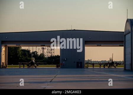 USA Die Air Force F-16 Fighting Falcons, die dem 180. Kampfflug der Ohio Nationalgarde zugeteilt ist, sitzt vor einem abendlichen Trainingsflug auf der 180FW in Swanton, Ohio, 22. August 2022 in einem Hangar. Der 180FW führt Tag und Nacht Training durch, bei Regen oder Schnee, um die Einsatzbereitschaft zu verbessern und sicherzustellen, dass Kampfkräfte jederzeit und überall an die Kommandeure geliefert werden können. Stockfoto