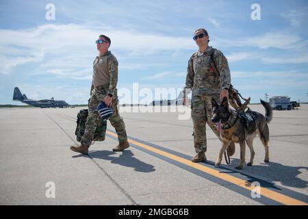 USA Air Force Staff Sergeant Ryan Keeny, 45. Sicherheitsgeschwader, Militär, Hundetrainer, und USA Air Force Staff Sgt. Tilar Brooks 45. SFS MWD Handler, geht mit Debra über die Fluglinie, 45. SFS MWD, am 23. August 2022, Patrick Space Force Base, Florida MWDs bieten Sicherheit für Patrick SFB und Cape Canaveral Space Force Station und sind ausgebildet, um die Einsatzbereitschaft zu gewährleisten. Stockfoto