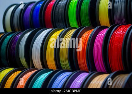 Viele mehrfarbige Filamentfäden für den Druck von 3D-Druckern. Materialspulen zum Drucken von 3D-Druckern. Spulen von 3D-Druckfilamenten in verschiedenen Farben. ABS-Kabel aus Kunststoff für 3D-Drucker Stockfoto